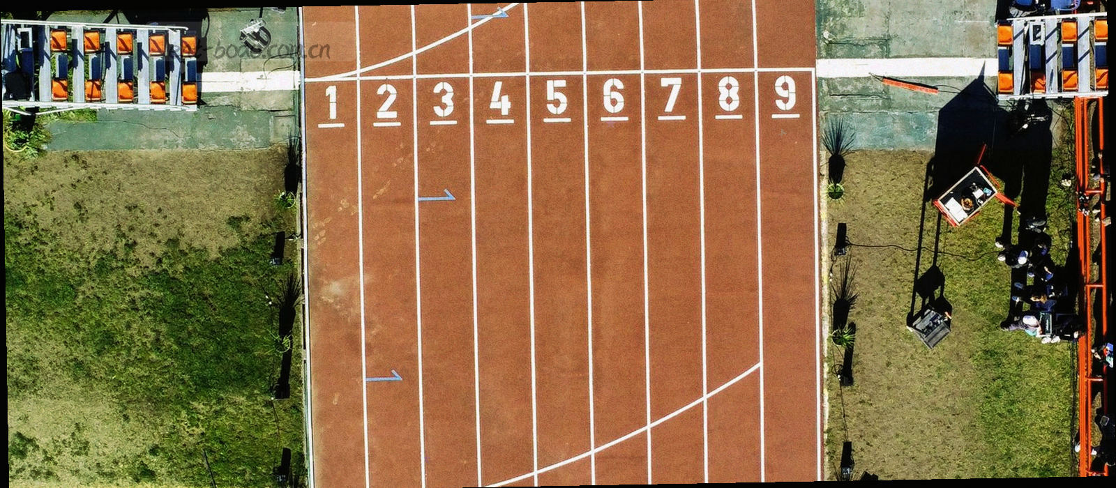 青岛海滨与球场远景的冷调航拍，画面克制，没有叠加任何文字